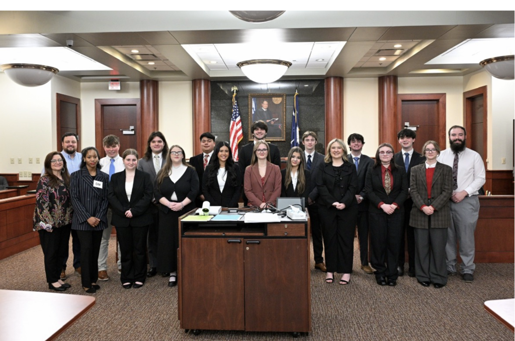 Group of students and teachers in court chambers.
