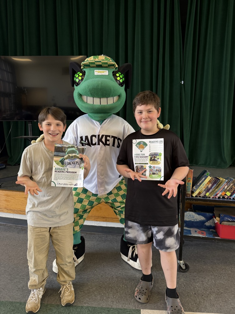 students posing with a baseball mascot that resembles a bug