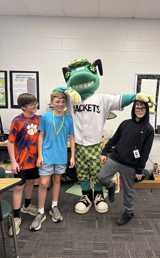students posing with a baseball mascot that resembles a bug