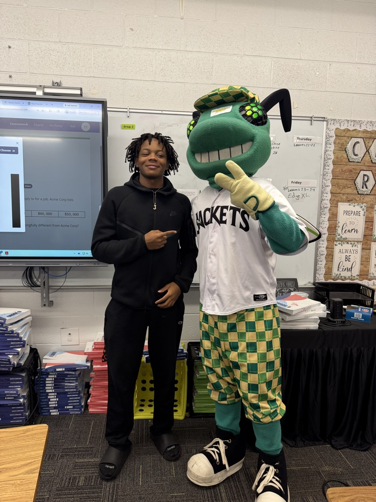 students posing with a baseball mascot that resembles a bug