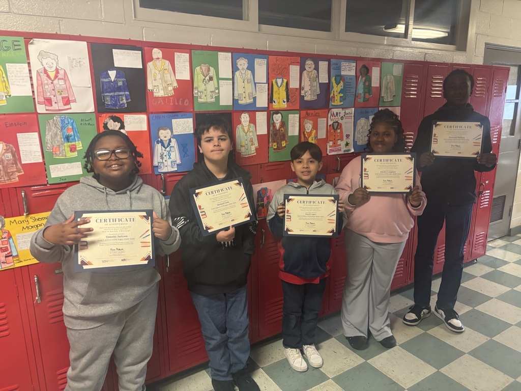 Students holding up a certificate for entering an essay contest.