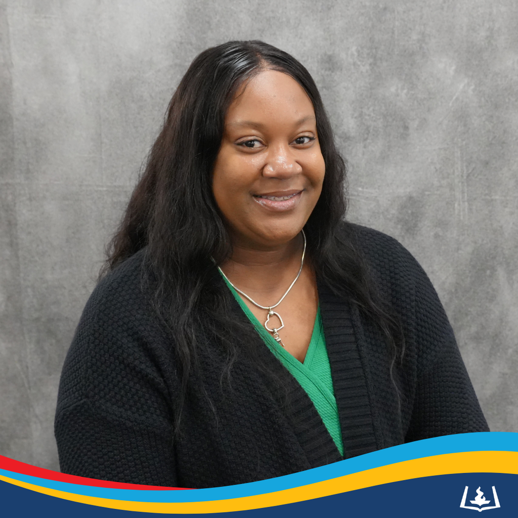 Lynetta smiling in green shirt and black cardigan.