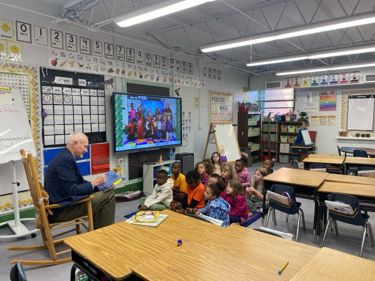 Guest reader reading to 1st grade students.