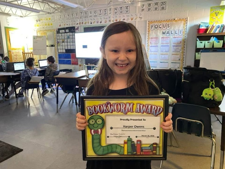 Student showing her bookmark contest award