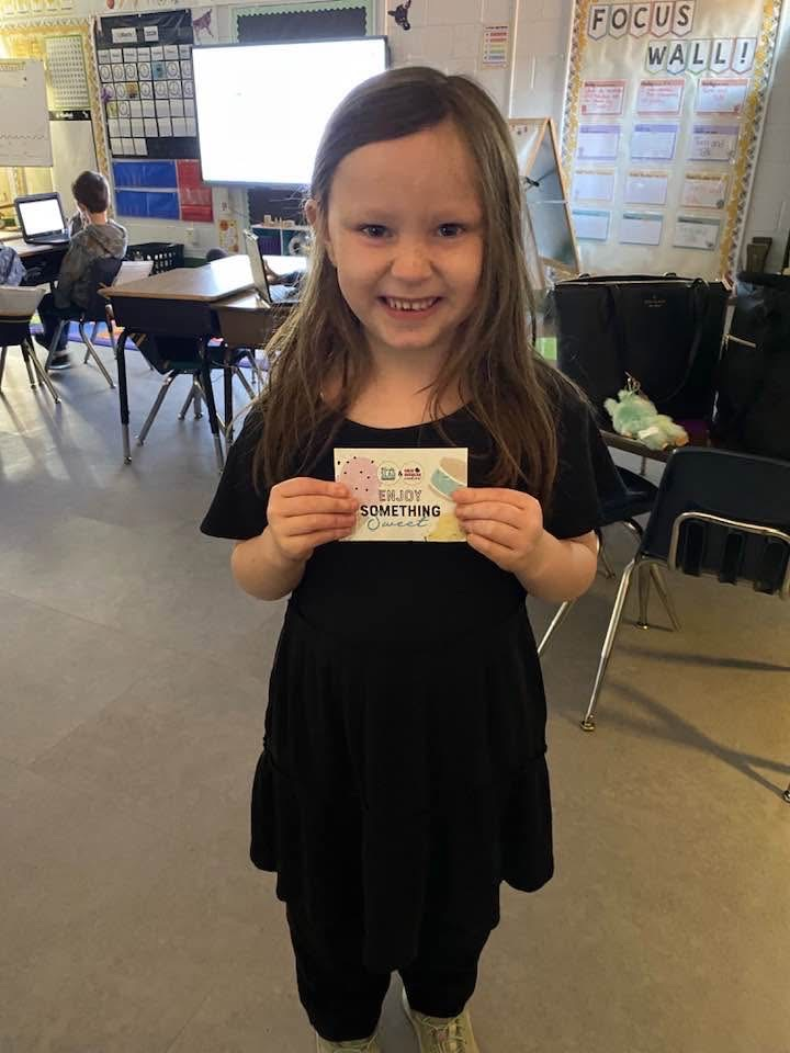 student showing her contest gift card