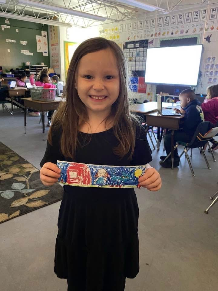student showing her winning bookmark