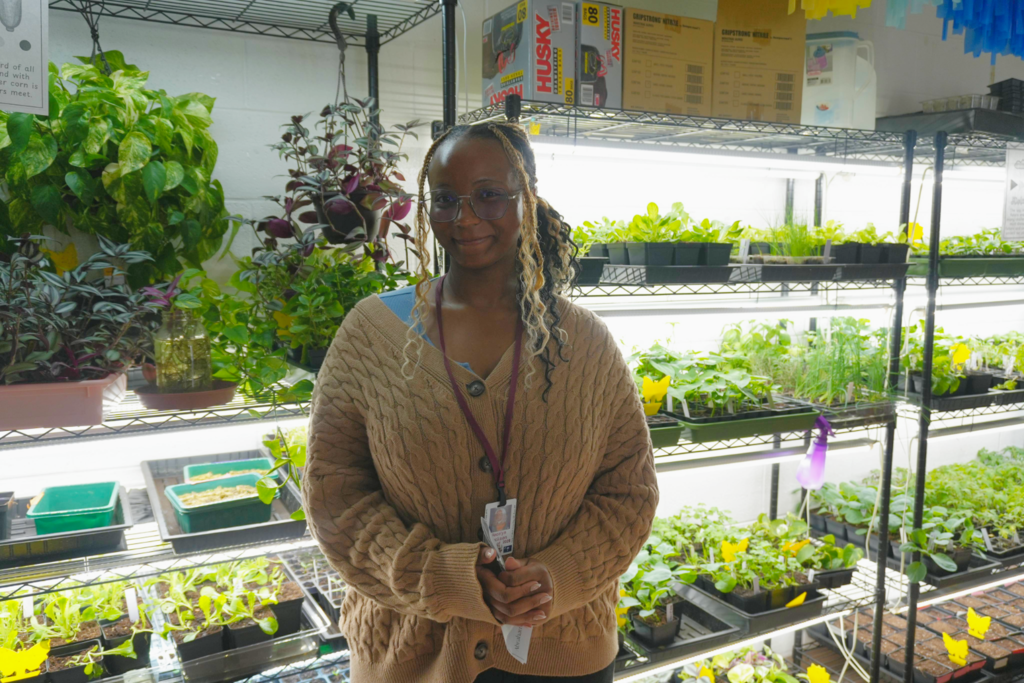 South Aiken High student in front of in door plants.