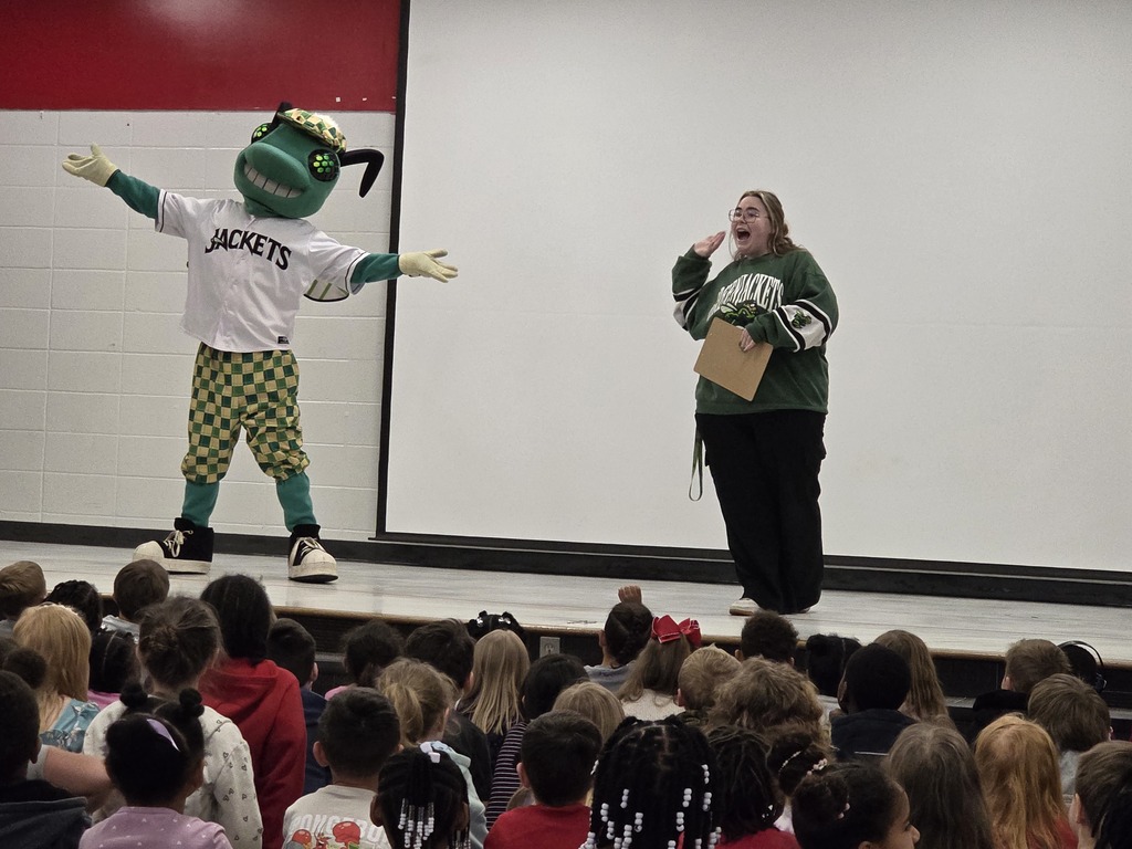 Mascot on stage with woman.