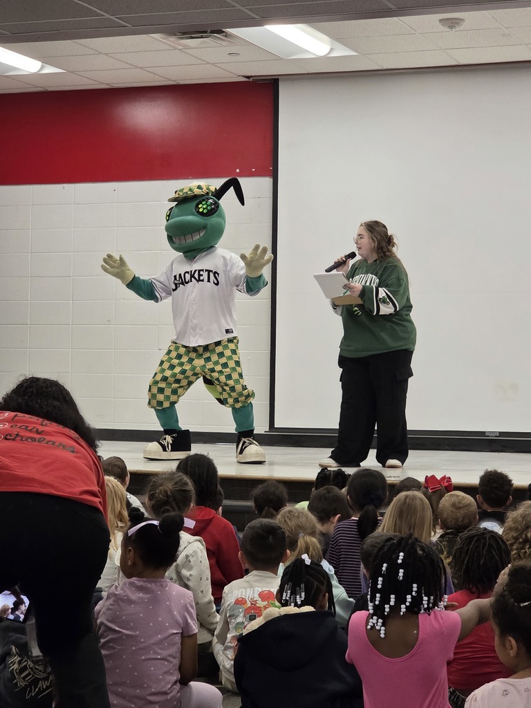 Mascot on stage with woman.
