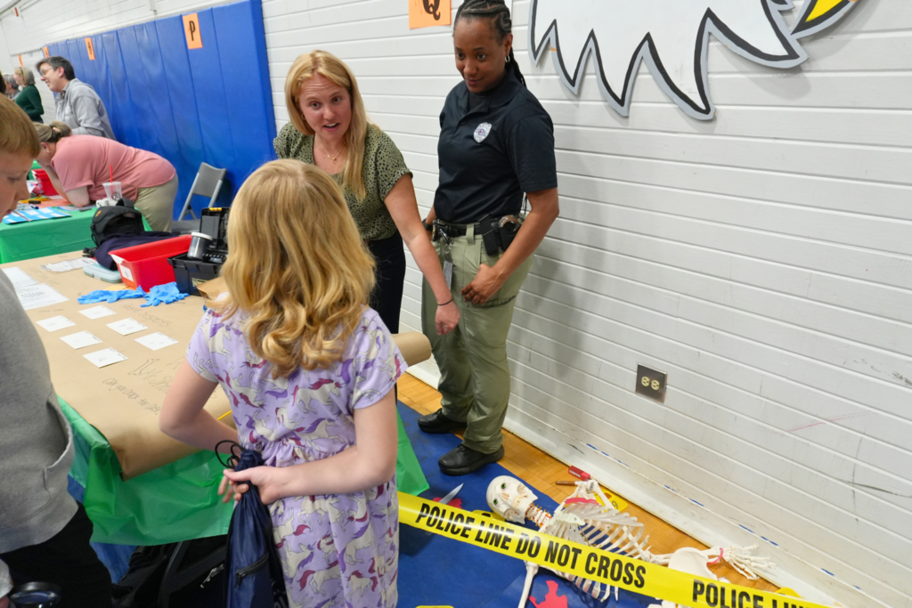 Student talking with staff at public safety booth.