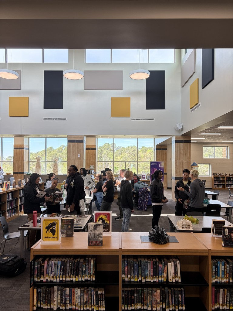 Group of students meeting with colleges in library.