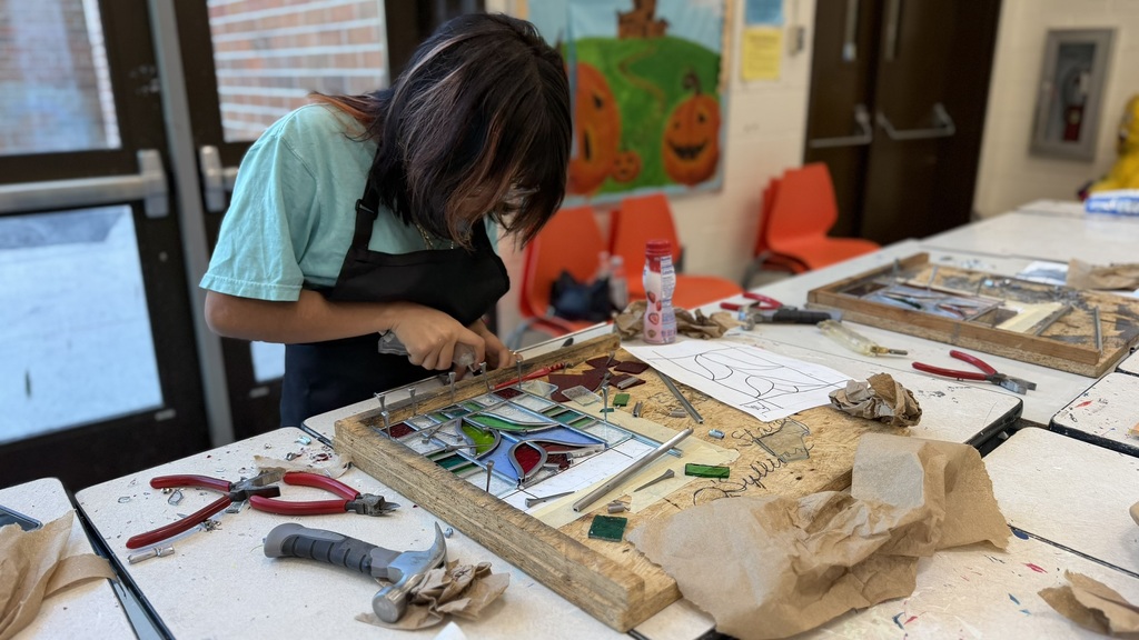 Student artist working on creating a stain-glass flower.