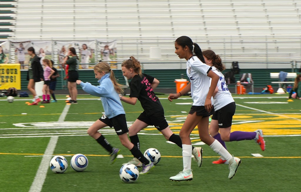 Athletes playing soccer at a camp.