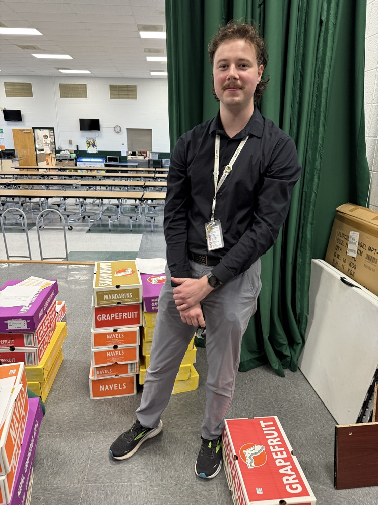 man posing with fruit boxes 