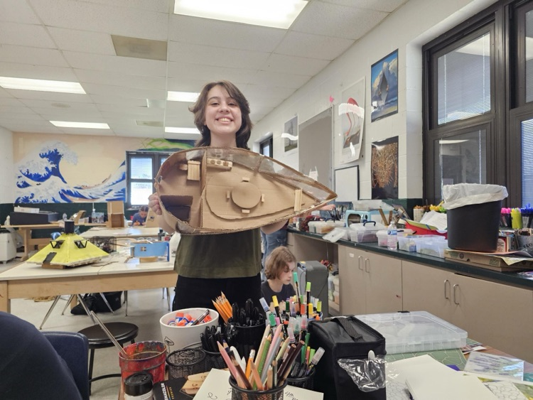 student holding an art project 