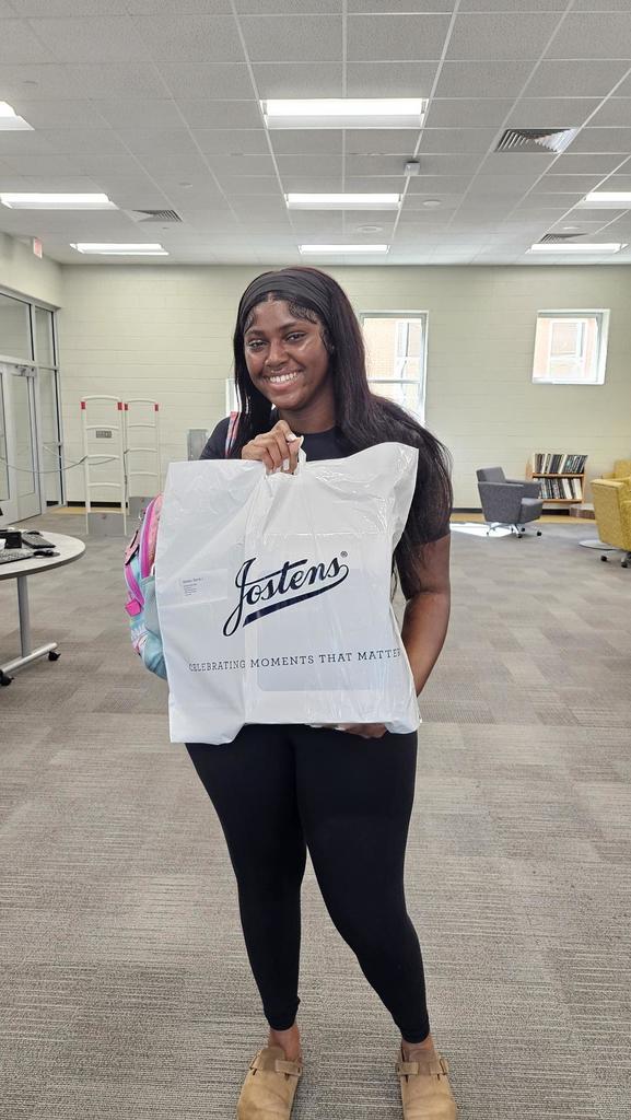 Female student hold Josten's Bag in library.