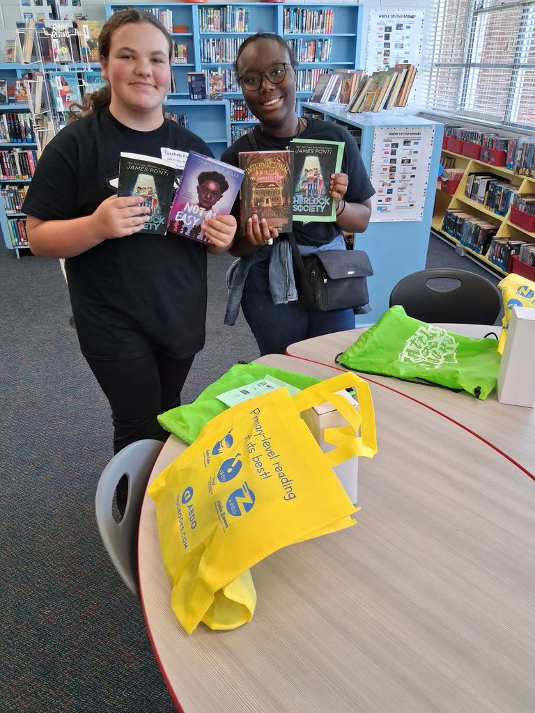 Students showing off their literature swag bag items.