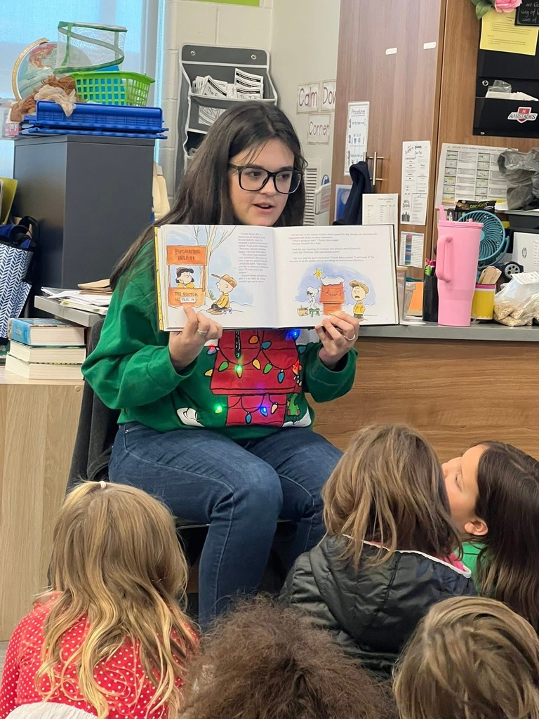 Volunteer reading story to students.