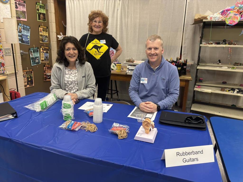 Group of volunteers sitting at table with cups.