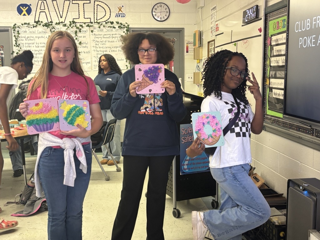 Three student displaying their poke artwork made during club day.