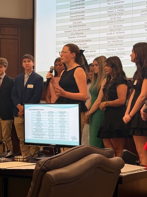 Student speaking at chamber meeting. 
