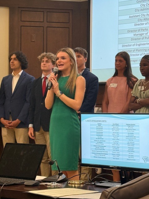Student speaking at chamber meeting. 