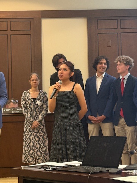 Student speaking at chamber meeting. 