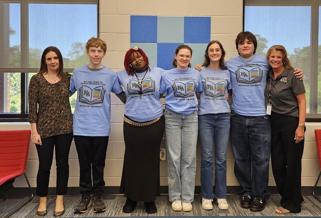 5 Students and teachers standing in front windows. 