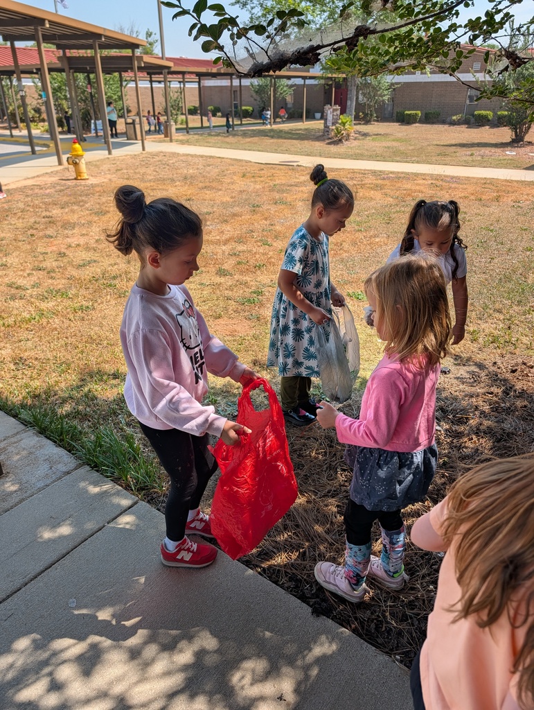 Students picking up trash around school grounds.