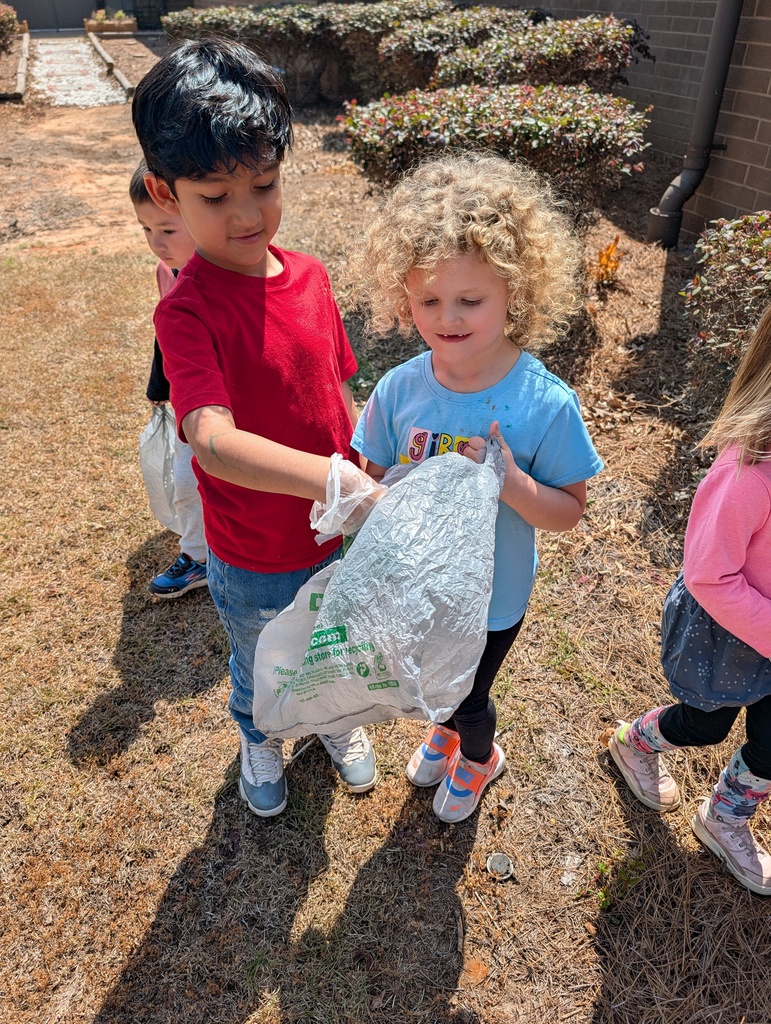 Students picking up trash around school grounds.