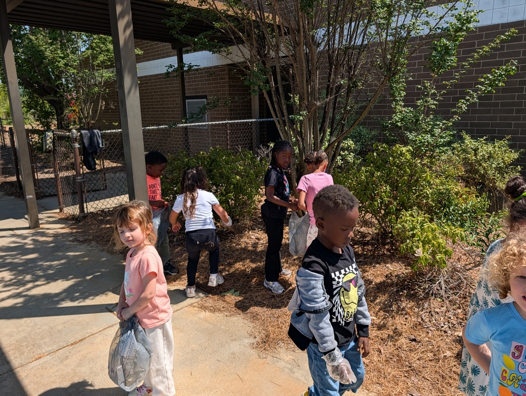 Students picking up trash around school grounds.