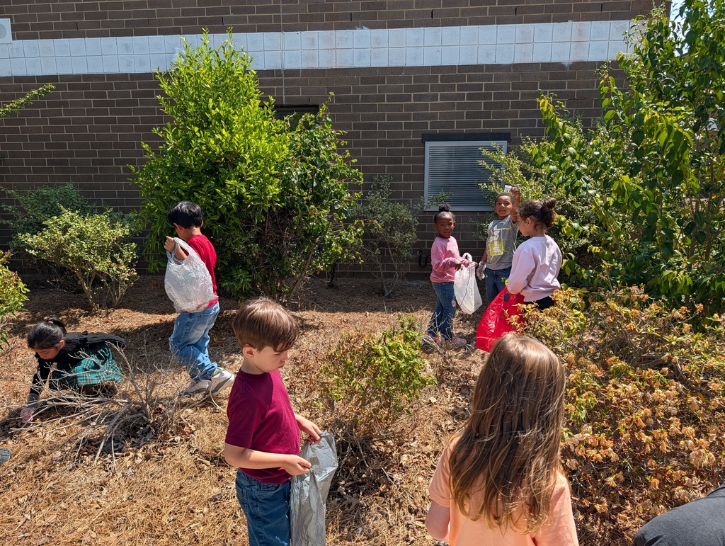 Students picking up trash around school grounds.