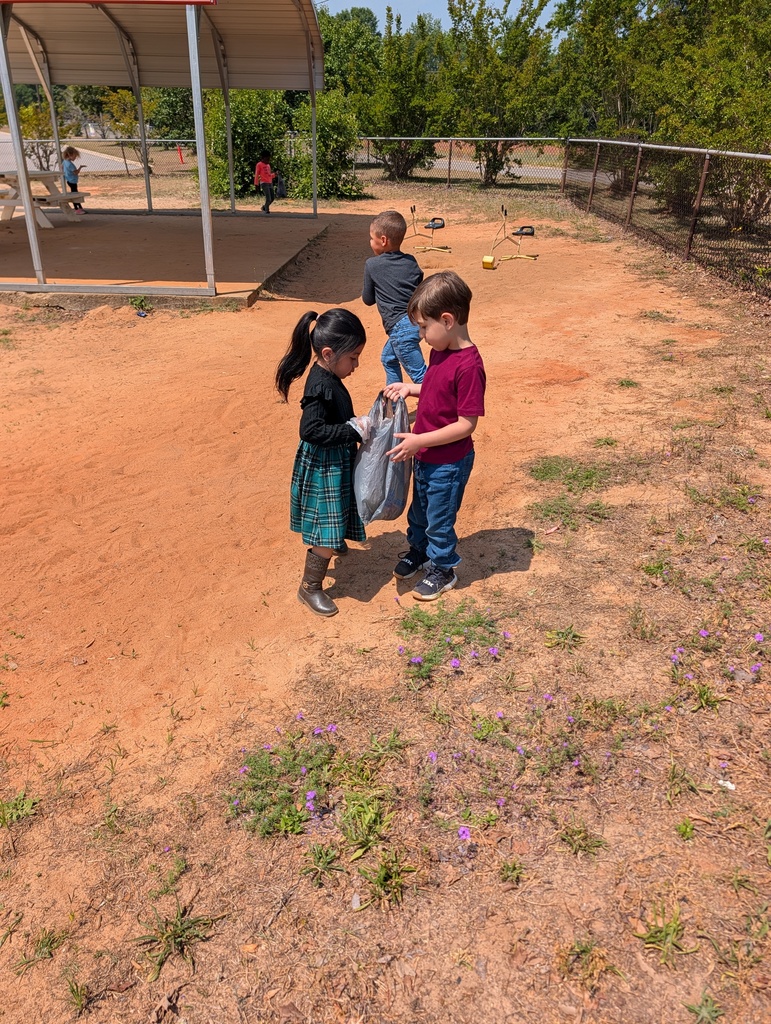 Students picking up trash around school grounds.