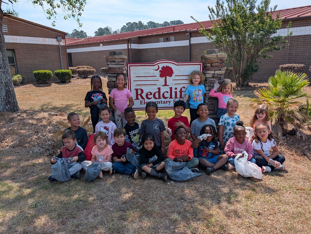 Students gathered around school sign.