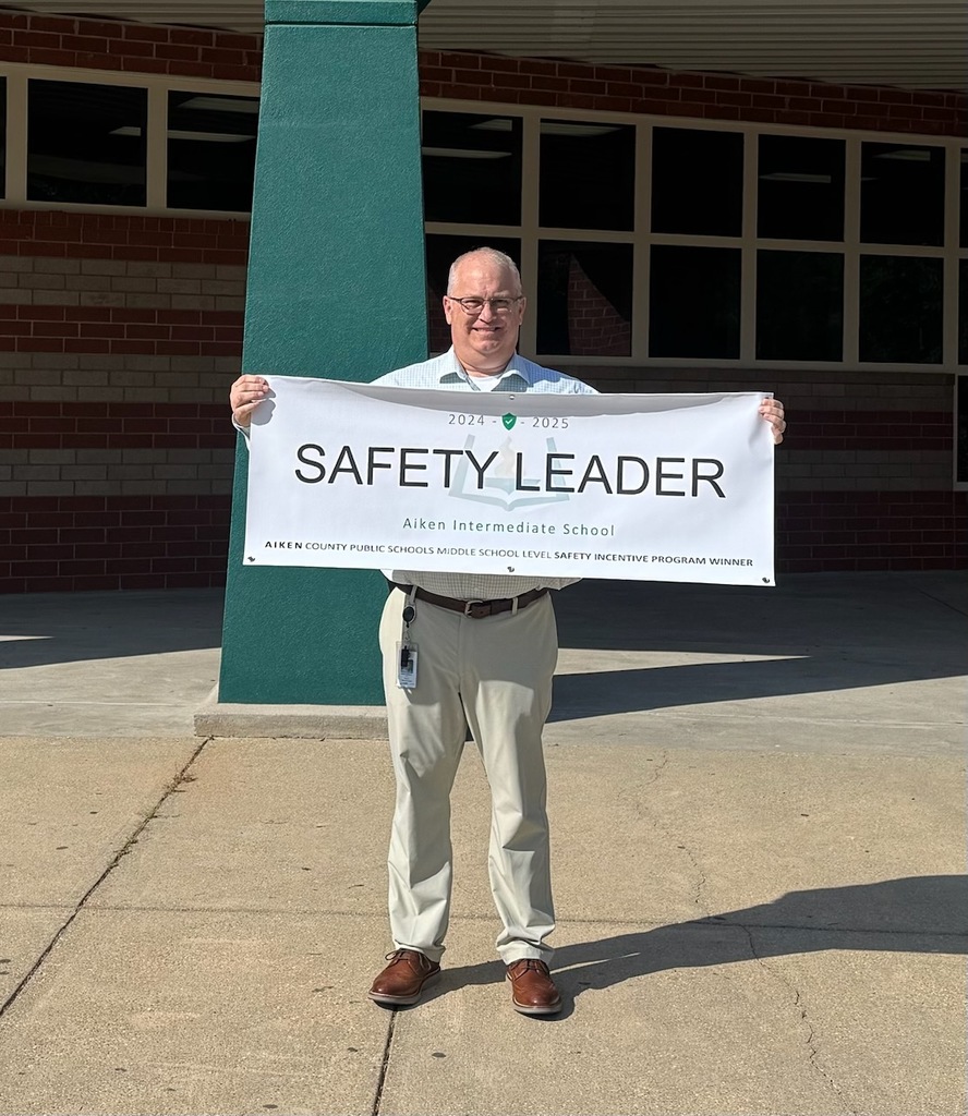Mr. Osbourne from Aiken Intermediate School holding a safety leader banner. 