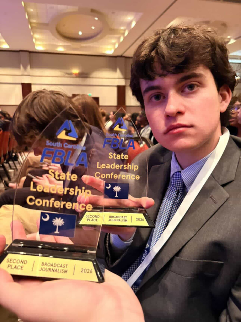 Student with awards at convention. 