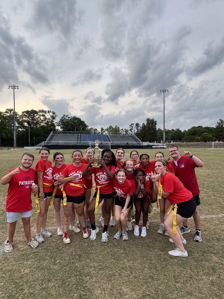 students and coaches holding trophy