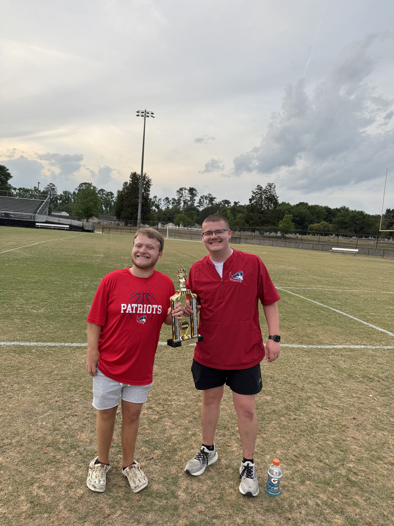 Coach Seymour and Coach Mcgee holding trophy