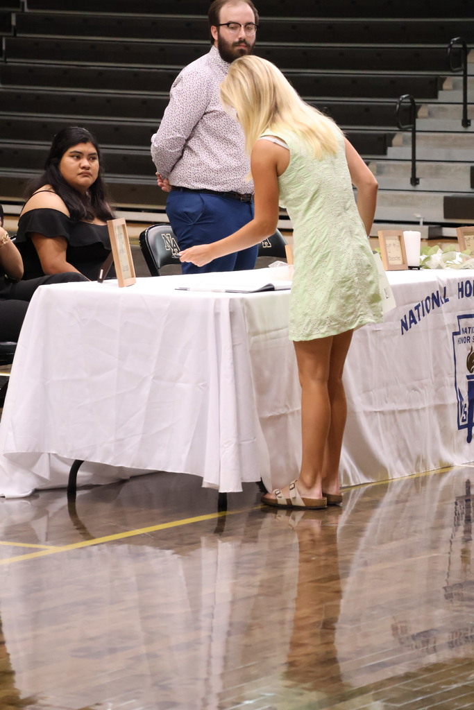 Girls at NHS table signing book. 