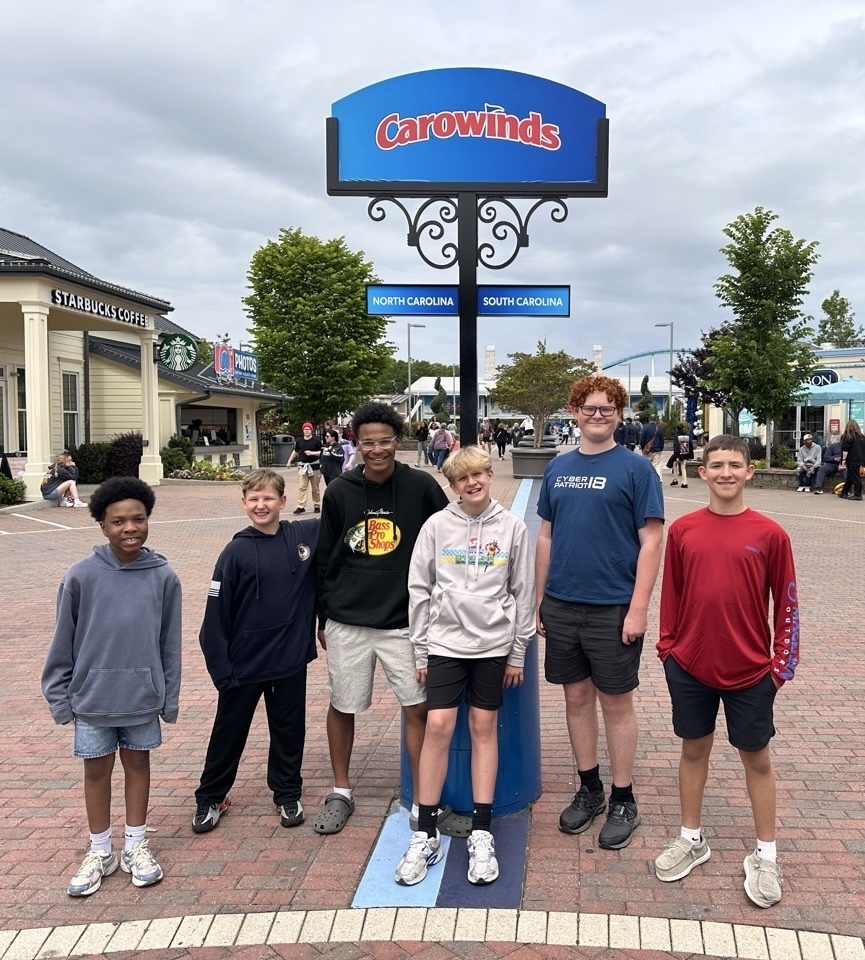 group of students around Carowinds sign
