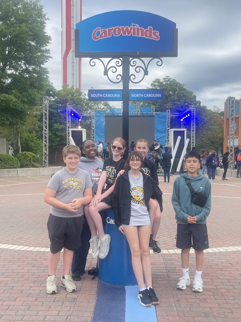 group of students around Carowinds sign