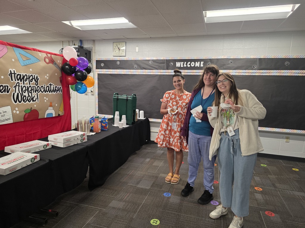 Three teachers with coffee and donuts.