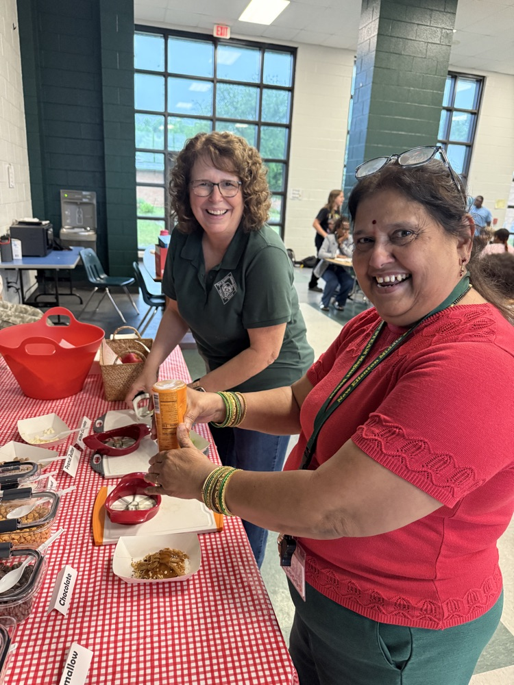 teachers smiling at a serving table 