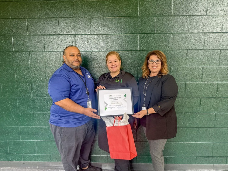 cafeteria staff holding a plaque 