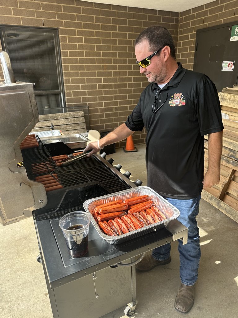 Man grilling hot dogs.