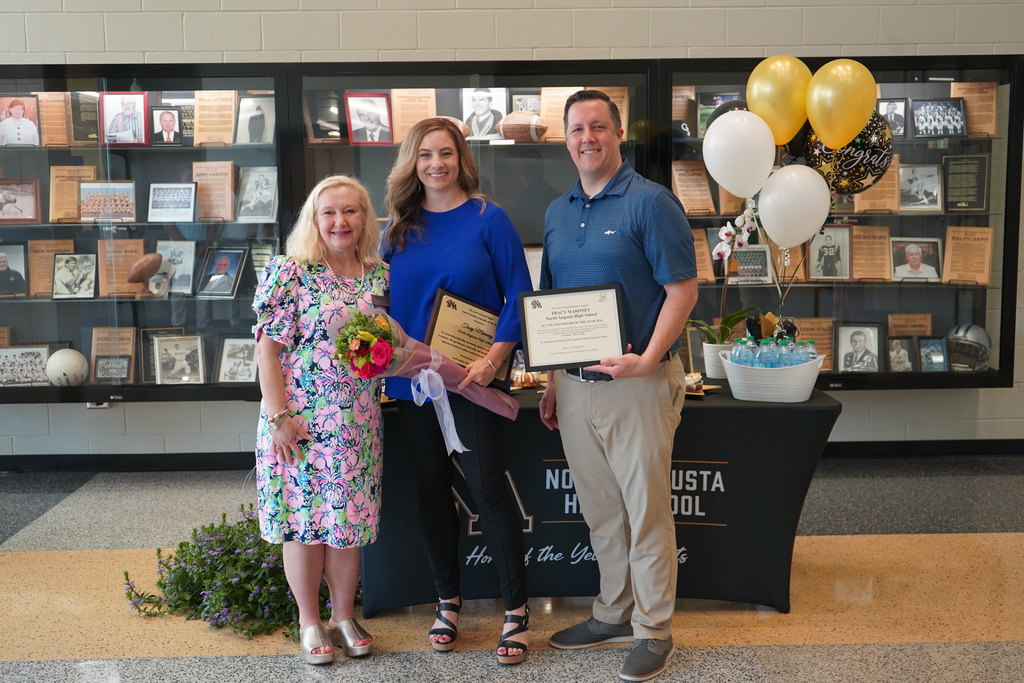 Tracy posed with family and principal.