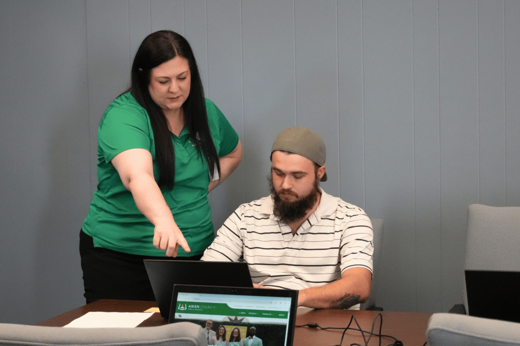 Hiring event attendee receiving help from HR recruiter.