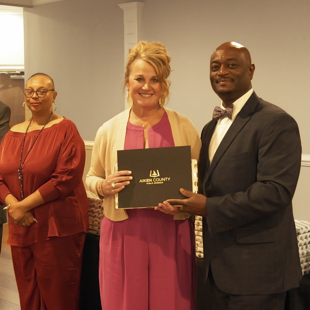 Retiree receiving a certificate and gift from Dr. Corey Murphy, Superintendent.