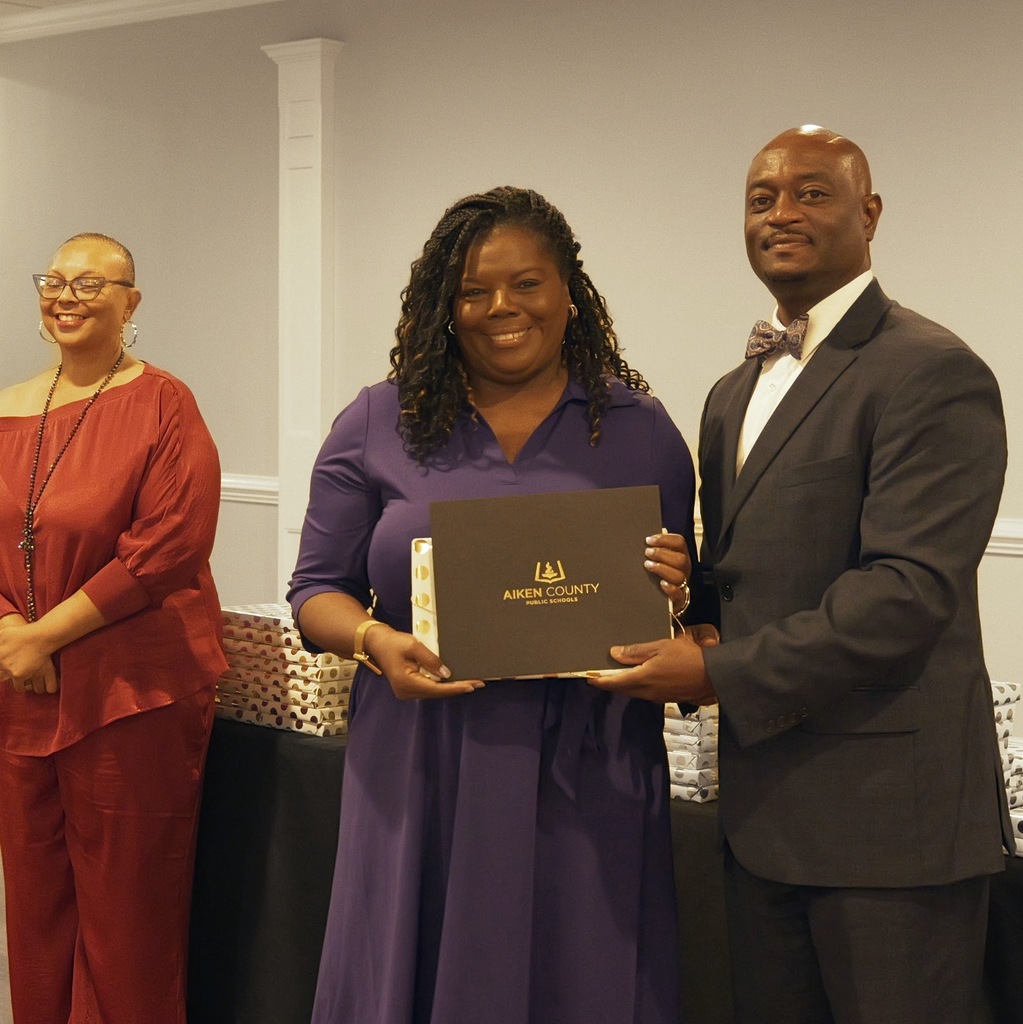 Retiree receiving a certificate and gift from Dr. Corey Murphy, Superintendent.