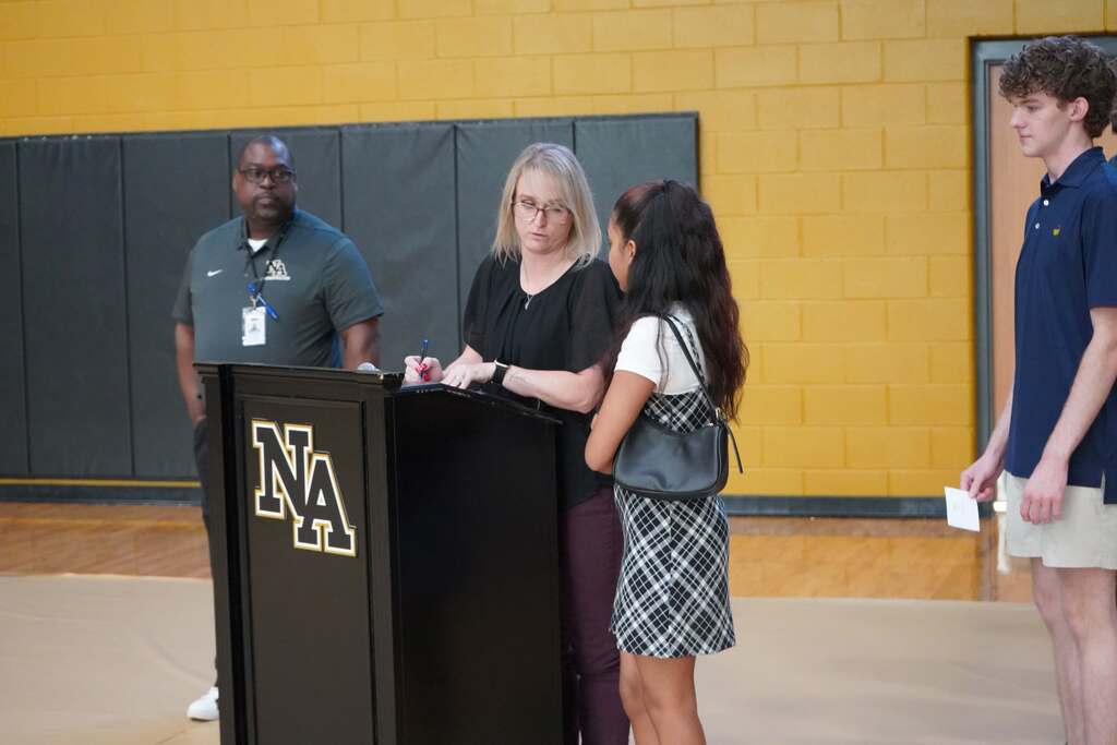 Admin speaking with student as another admin and student look on. 